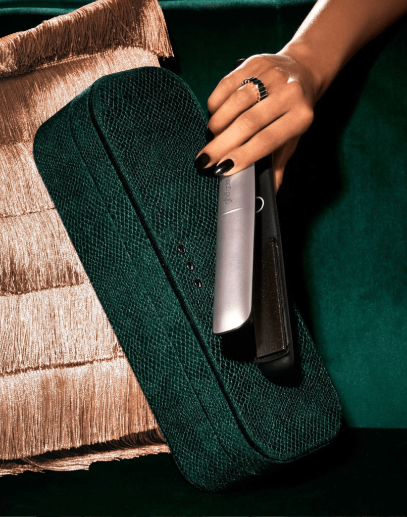 A shot of hands holding GHD hair straighteners. This has a very luxurious feel to it as the background is the base of a velvet emerald green sofa with champagne coloured fringed pillows. The hands have a jet black manicure on the nails which i had created to compliment the style of this shoot.